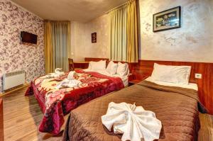 een hotelkamer met 2 bedden in een kamer bij Вили Forest Nook in Pamporovo