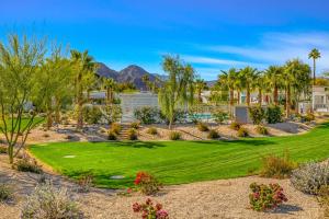 a yard with a green lawn and palm trees at Artfully Indian Wells in Indian Wells