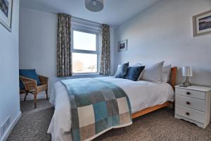 a bedroom with a large bed and a window at Spindrift - views of Chesil beach dog friendly in Weymouth