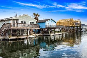 a group of houses on a dock on a body of water at Bungalow by the Bay in Galveston