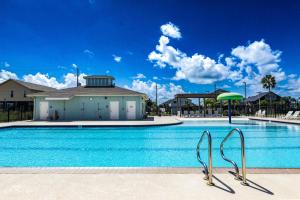 a large swimming pool with a building in the background at Bungalow by the Bay in Galveston