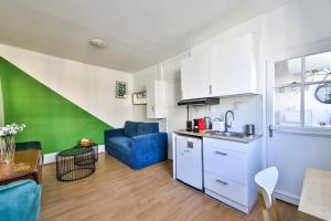 kuchnia i salon z niebieskim krzesłem i stołem w obiekcie 41.Studio 2Pers#Sèvres-Lecourbe#Necker w Paryżu