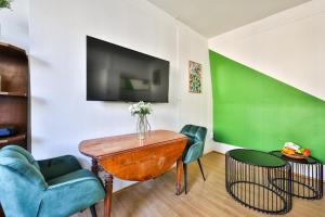 salon ze stołem, krzesłami i telewizorem w obiekcie 41.Studio 2Pers#Sèvres-Lecourbe#Necker w Paryżu