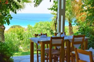 a table with chairs and a view of the ocean at Hotel Plakures in Falasarna