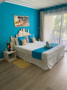 a bedroom with a large bed with blue walls at La Villa Soalic in Cilaos