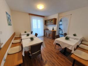 Haus Beim Seppl في ناتورنو: غرفة طعام مع طاولات وكراسي ومطبخ