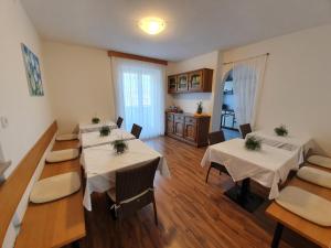 a dining room with tables and chairs and a kitchen at Haus Beim Seppl in Naturno