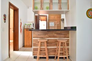 una cocina con 2 taburetes de madera en un mostrador en Conforto e Aconchego no Rio Vermelho P2145, en Florianópolis