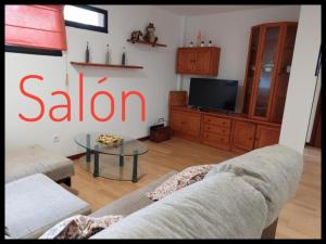 - un salon avec un canapé et une télévision dans l'établissement Casa Santa Tecla A Guarda, à A Guarda