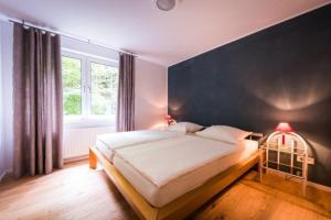 1 dormitorio con 1 cama grande y pared negra en GASTHAUS Porzelt-Ferien im Weingut-Wohnung 3, en Klingenmünster