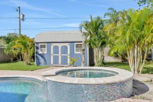 a house with a swimming pool in front of a house at Pinellas Retreat in Pinellas Park