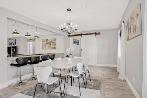 a dining room with a white table and chairs at Pinellas Retreat in Pinellas Park