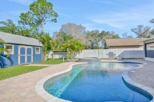 a swimming pool in a yard next to a house at Pinellas Retreat in Pinellas Park