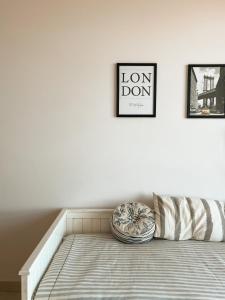 um quarto branco com uma cama e duas fotografias na parede em Hermoso departamento nuevo en Bahía Blanca piso 4 em Bahía Blanca