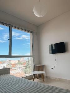um quarto com uma cama e uma grande janela em Hermoso departamento nuevo en Bahía Blanca piso 4 em Bahía Blanca