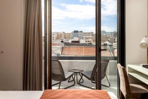 a bedroom with a balcony with a view of a city at Empire Marquês Hotel in Lisbon