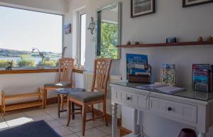 a room with a desk and two chairs and a window at Tarradale Cottage in Portree
