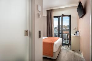 a hotel room with a bed and a balcony at Empire Marquês Hotel in Lisbon