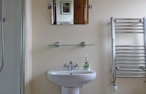 a bathroom with a sink and a mirror at Tarradale Cottage in Portree