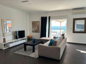 a living room with a couch and a tv at Sunset Apartment in Orasac