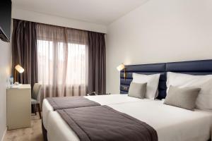 a hotel room with a large bed and a window at Empire Marquês Hotel in Lisbon