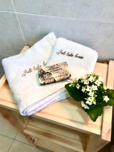 - deux serviettes assises sur un banc fleuri dans l'établissement IULI LAKE HOME Tra lago e montagna, à Olginate