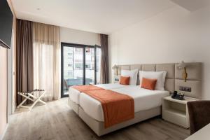 a bedroom with a large bed and a large window at Empire Marquês Hotel in Lisbon