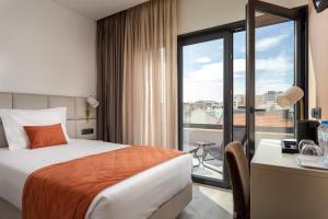 a hotel room with a bed and a window at Empire Marquês Hotel in Lisbon
