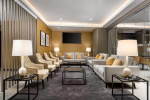 a living room with couches and chairs and tables at Empire Marquês Hotel in Lisbon
