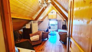 sala de estar con techo de madera y sillas en Le Doux Nid en Chanaz