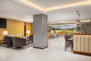 a lobby with chairs and a bar in a building at Empire Marquês Hotel in Lisbon