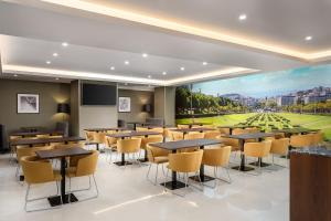 a conference room with tables and chairs and a large window at Empire Marquês Hotel in Lisbon