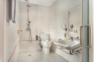 a white bathroom with a toilet and a sink at Empire Marquês Hotel in Lisbon +37 photos