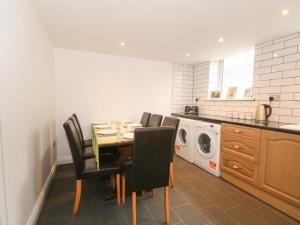 a kitchen with a table and chairs and a washing machine at Butterfly Cottage in Rossendale