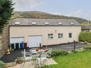 a patio with a table and chairs in front of a house at Butterfly Cottage in Rossendale