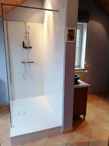 prysznic w pokoju z białą ścianą w obiekcie Les2sources Bike-B&B w mieście Rochefort