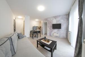 uma sala de estar com um sofá e uma televisão na parede em Pegasus apartments em Belgrado