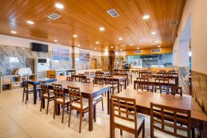 een restaurant met houten tafels en houten stoelen bij Hotel Santa Catarina Algarve in Portimão