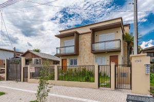 una casa con una puerta y una valla en Casa Sta Terezinha - Stay House Temporada, en Canela