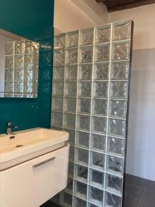 baño con lavabo y ducha con paredes de cristal. en Villa Mogador en Esauira