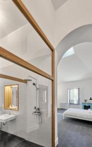 ein Bad mit einer Dusche, einem Waschbecken und einem Bett in der Unterkunft Château de Sibra in Lagarde