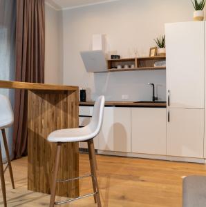 a kitchen with white cabinets and a white refrigerator at BohoAlbatross in Ķesterciems