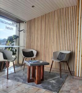 a room with two chairs and a wooden wall at Anoitecer Itinerante AL - antiga residencial o garfo in Ponte de Lima