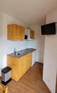 eine kleine Küche mit einer Spüle und einer Mikrowelle in der Unterkunft Orelle Val Thorens Appartement 2 pieces 5 personnes aux portes du Parc de la Vanoise in Orelle