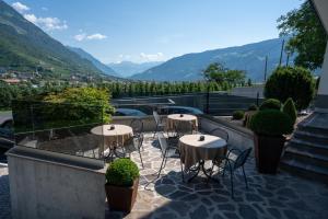 a patio with tables and chairs on a balcony with mountains at Haus Beim Seppl in Naturno