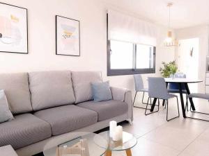 un salon avec un canapé et une table dans l'établissement Groundfloor Pink Ciñuelica -Winter by the sea, à Orihuela Costa