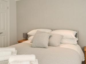 sypialnia z 2 łóżkami i białymi poduszkami w obiekcie Carolina Cottage - Uk42877 w mieście Wilberfoss