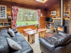 a living room with leather furniture and a fireplace at Ard Darach Lodge in Brinscall