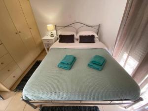 duże łóżko z dwoma zielonymi ręcznikami w obiekcie Villa Evgenia w mieście Asprouliánoi