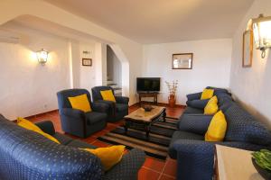 una sala de estar con sofás azules y almohadas amarillas. en Dom Nuno - Turismo de Habitacao, en Monsaraz